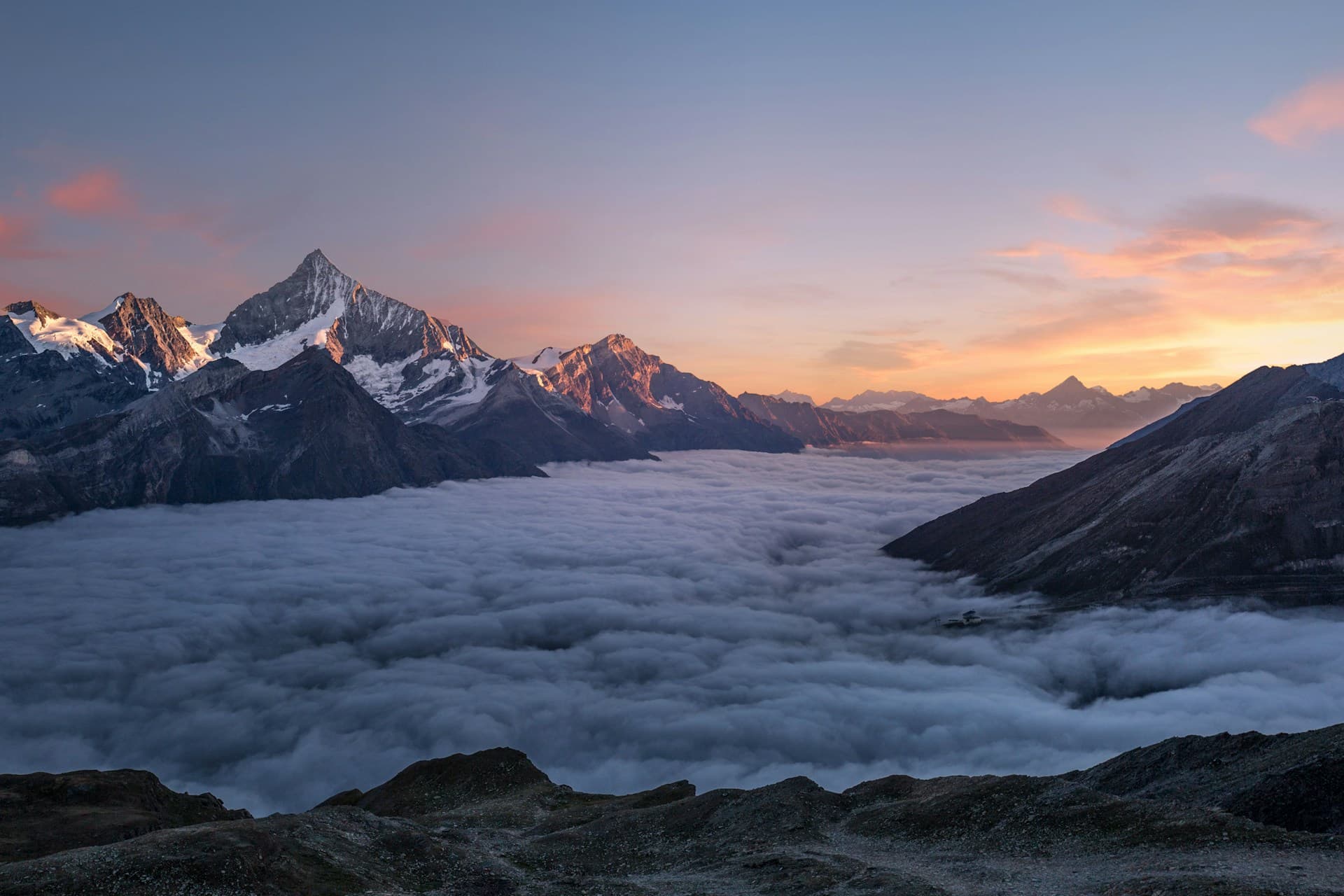 Stunning mountain peaks above clouds at sunrise